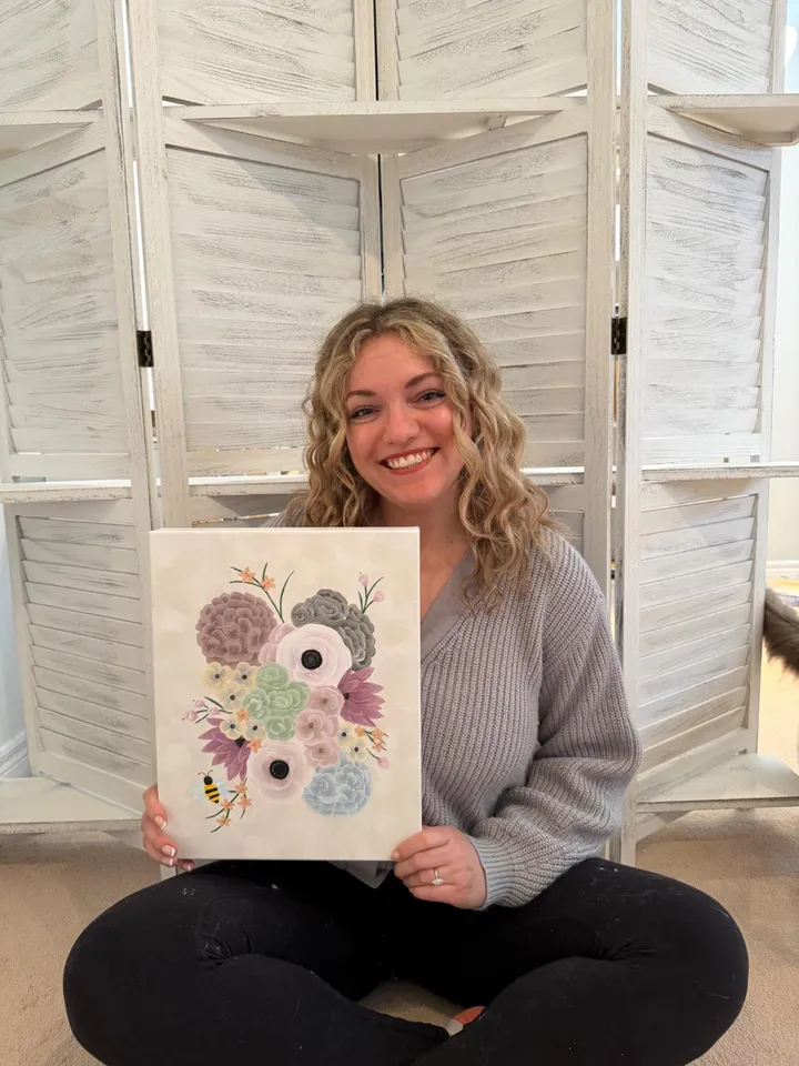 Nicole holding the finished acrylic floral painting